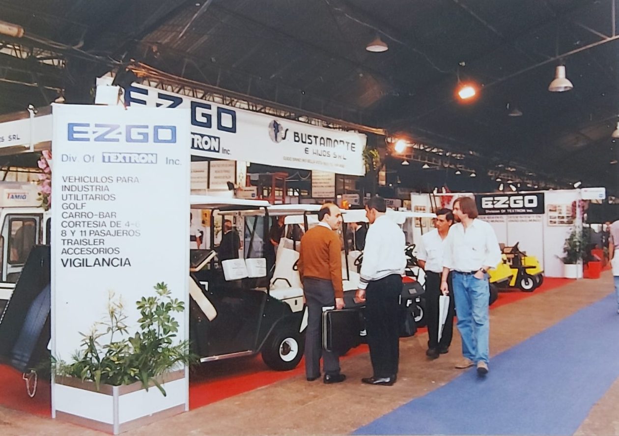 Stand de E-Z-GO y S. Bustamante e Hijos con visitantes en exposición industrial